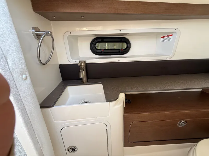 Slide: The Image of Interior of the 2017 Sea Ray SDX 290 with a sink and storage area. - 22
