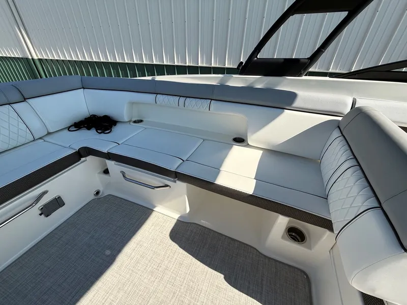 Slide: The Image of The image shows the seating area of a 2017 Sea Ray SDX 290 boat with white upholstery. - 23