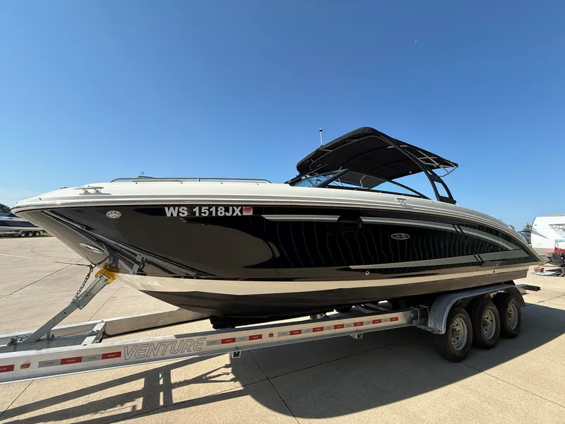 Slide: The Image of A 2017 Sea Ray SDX 290 boat on a trailer. It features a black hull design and a sunshade. - 2