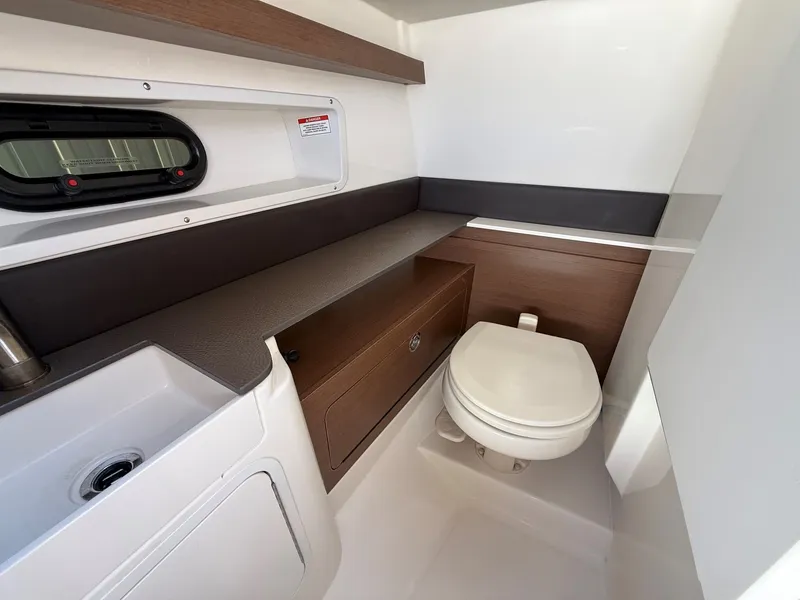 Slide: The Image of The image shows a modern boat bathroom with a sink, toilet, and storage space. - 21