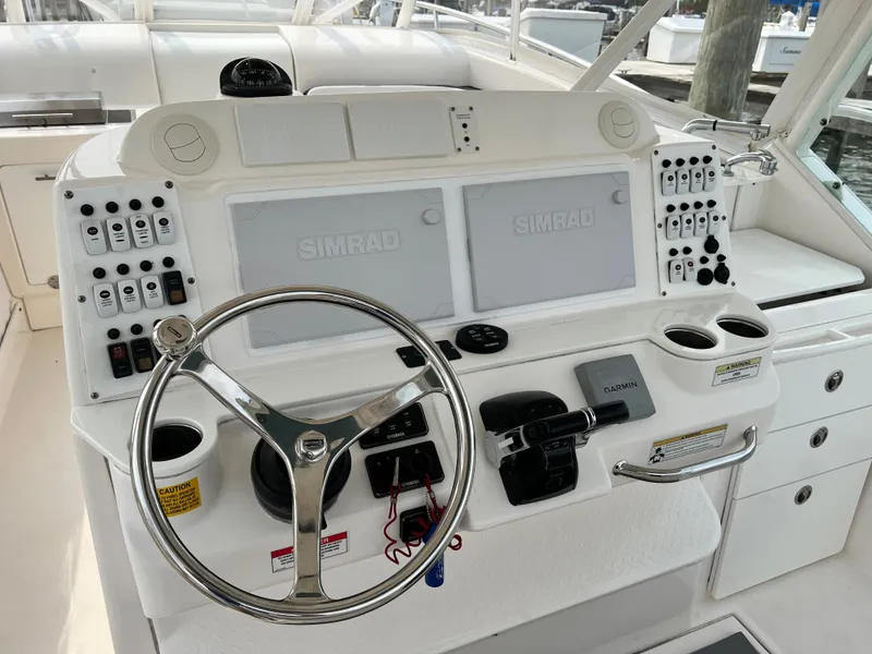 Slide: The Image of Helm of 2012 Everglades 350LX boat with dual Simrad displays and steering wheel. - 35