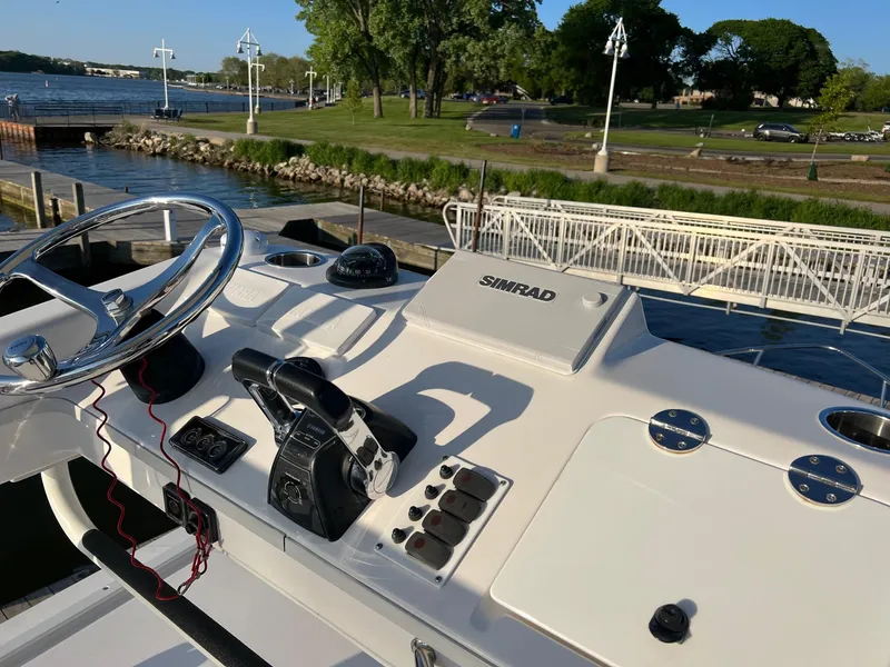 Slide: The Image of Helm of 2012 Everglades 350LX boat with Simrad navigation, docked by a scenic river. - 24