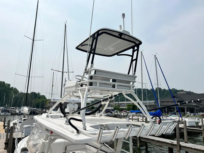 Slide: The Image of 2012 Everglades 350LX boat docked at a marina with sailboats in the background. - 15