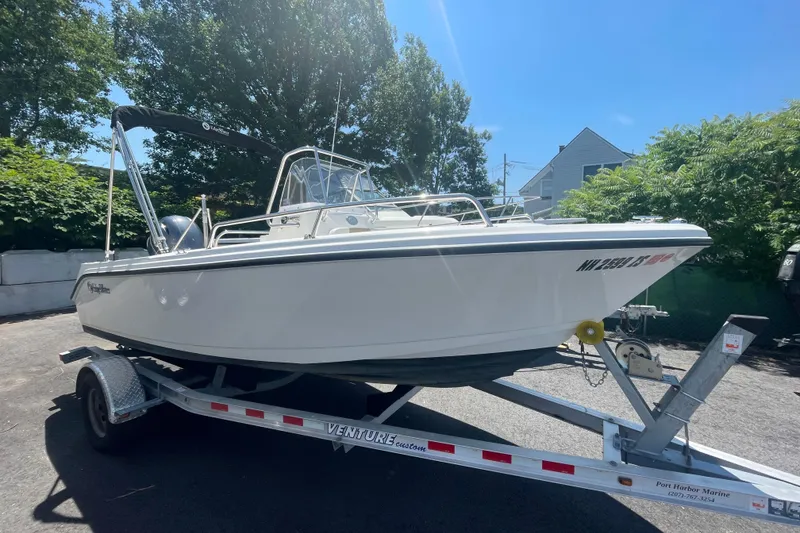 The Image of 2021 Edgewater 170CC boat on trailer, parked outdoors under clear blue sky. - 0