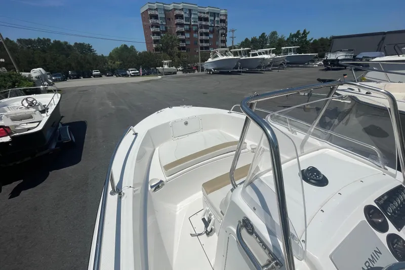 Slide: The Image of 2021 Edgewater 170CC boat in a marina with other vessels and a building in the background. - 4