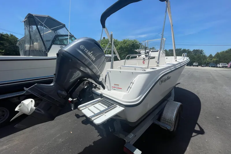 Slide: The Image of 2021 Edgewater 170CC boat with Yamaha outboard motor on trailer, parked outdoors. - 3