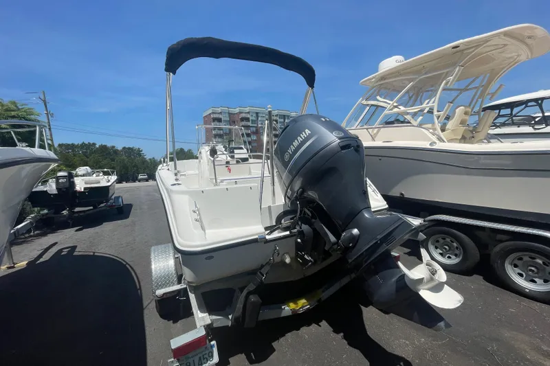 Slide: The Image of 2021 Edgewater 170CC boat with Yamaha outboard motor on a trailer, parked outdoors. - 2