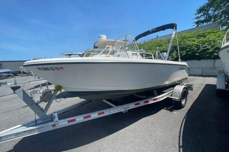 Slide: The Image of 2021 Edgewater 170CC boat on trailer, parked outdoors under clear blue sky. - 1
