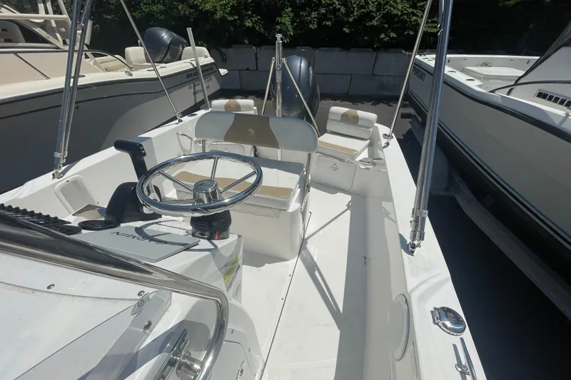 Slide: The Image of 2021 Edgewater 170CC boat interior with steering wheel and seating. - 9
