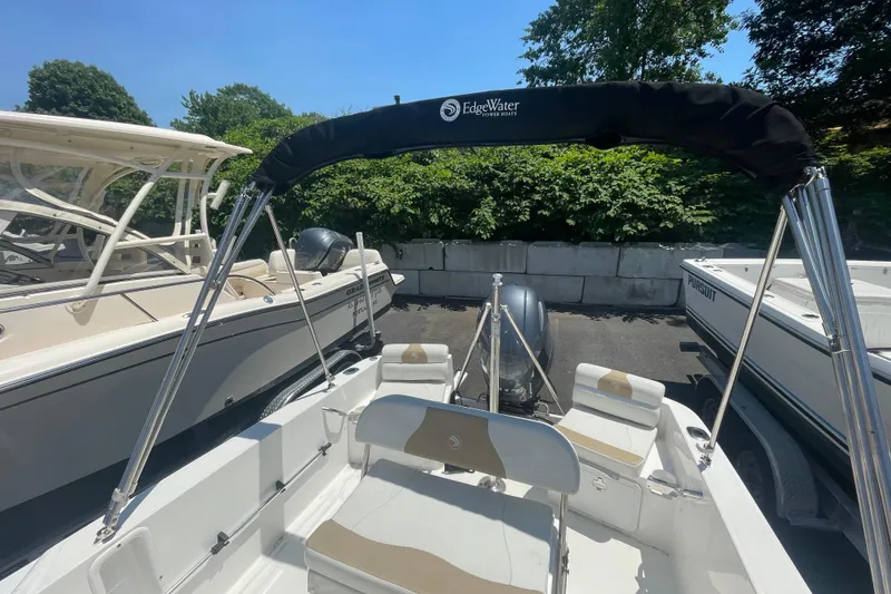 Slide: The Image of 2021 Edgewater 170CC boat with canopy, parked among other boats. - 8