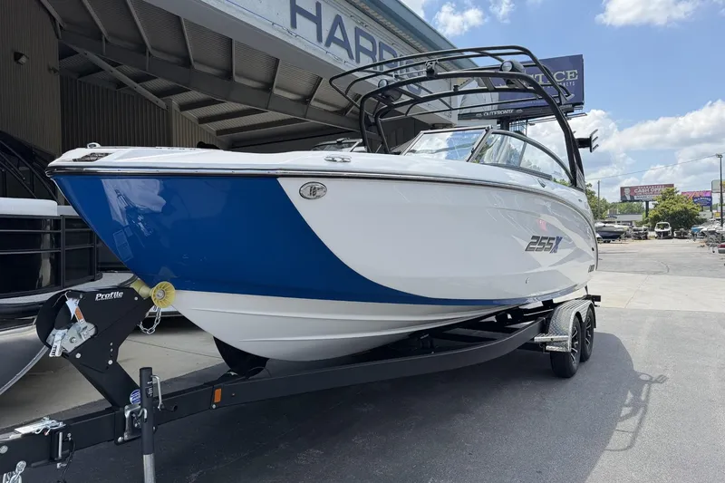 Slide: The Image of 2026 Yamaha Boats 255XE on trailer, blue and white design, parked outdoors. - 3