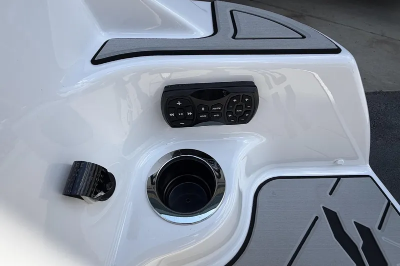 Slide: The Image of 2026 Yamaha Boats 255XE control panel with cup holder and audio controls. - 8
