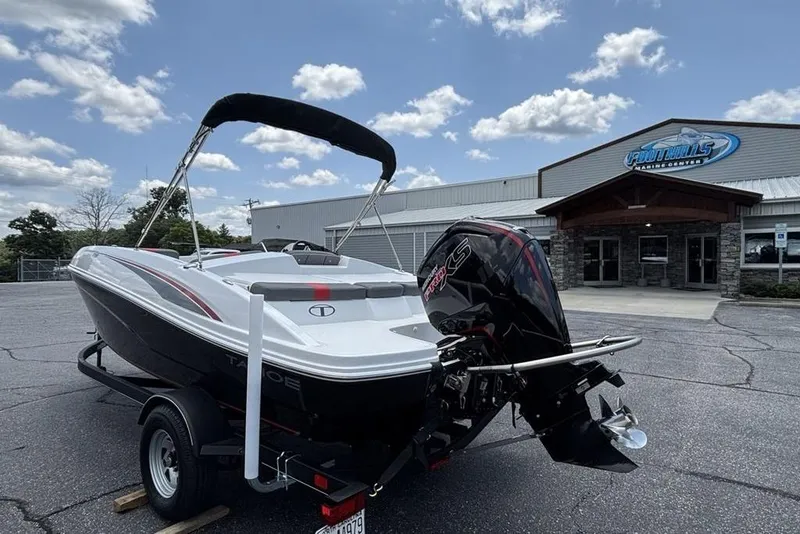 Slide: The Image of 2024 Tahoe T18 boat on trailer outside dealership under cloudy sky. - 11