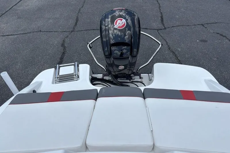 Slide: The Image of 2024 Tahoe T18 boat with outboard motor and cushioned seating on a paved surface. - 30