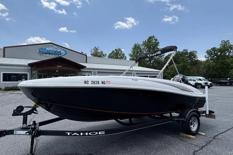 Slide: The Image of 2024 Tahoe T18 boat on trailer at dealership, clear sky background. - 4