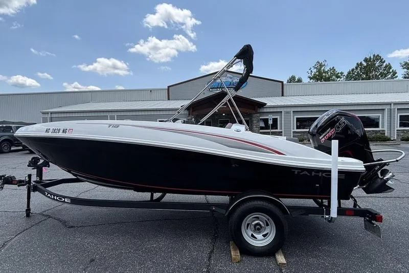 Slide: The Image of 2024 Tahoe T18 boat on trailer, parked outside a building under a clear sky. - 33
