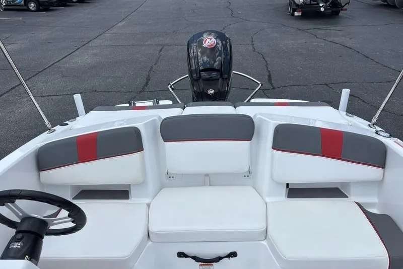 Slide: The Image of 2024 Tahoe T18 boat interior with gray and red seating, steering wheel, and outboard motor. - 25