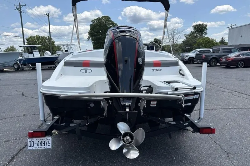Slide: The Image of 2024 Tahoe T18 boat rear view with outboard motor in a parking lot. - 2