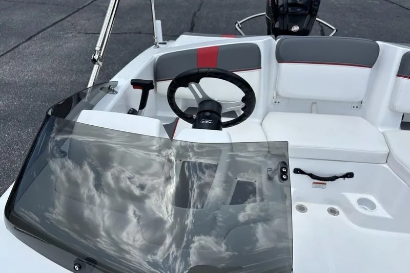Slide: The Image of 2024 Tahoe T18 boat interior with steering wheel and seating, featuring a sleek windshield design. - 19