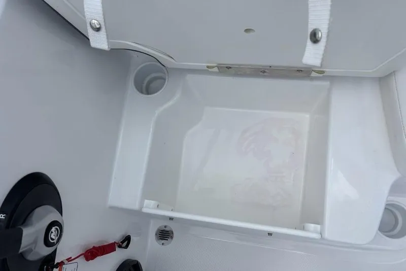 Slide: The Image of 2024 Tahoe T18 boat storage compartment with cup holders and latch. - 22