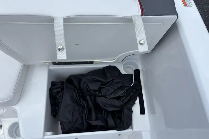 Slide: The Image of Open storage compartment in 2024 Tahoe T18 boat with black fabric inside. - 29
