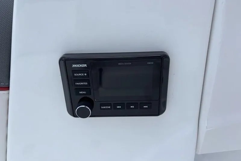 Slide: The Image of Kicker media center on 2024 Tahoe T18 boat dashboard, featuring control buttons and display. - 28