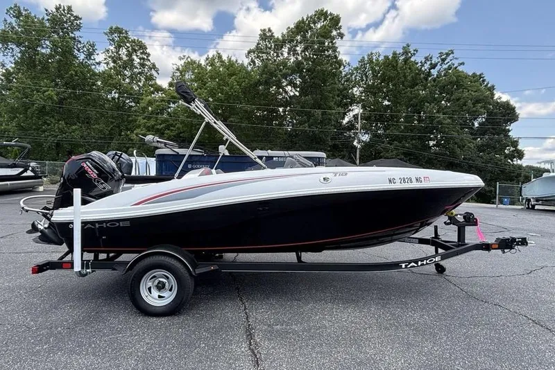 Slide: The Image of 2024 Tahoe T18 boat on trailer, parked outdoors under a cloudy sky. - 32