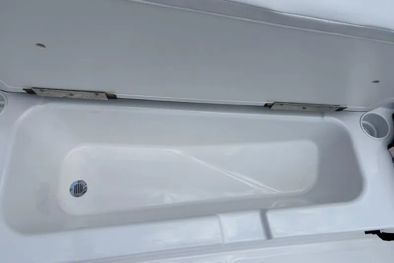 Slide: The Image of 2024 Tahoe T18 boat storage compartment with drain and cup holder. - 10