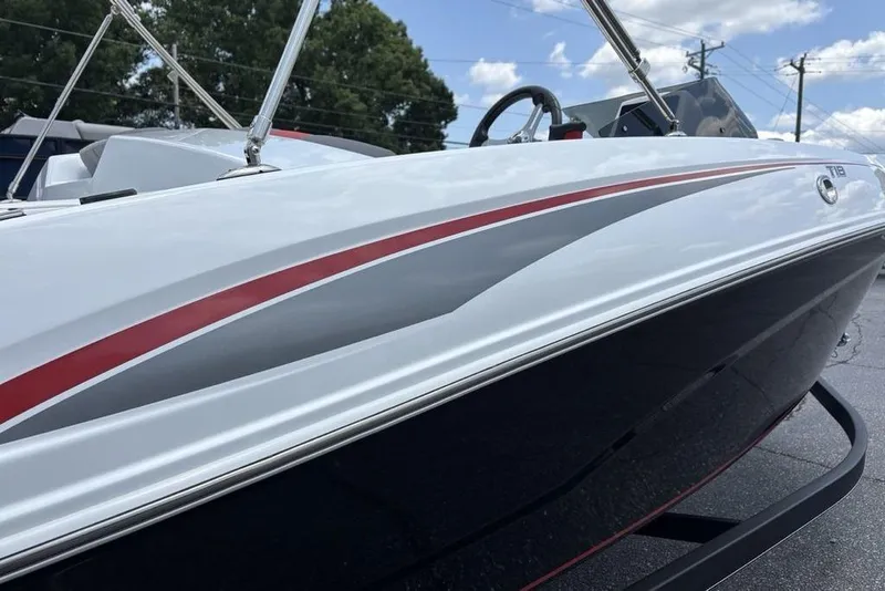 Slide: The Image of 2024 Tahoe T18 boat with sleek red and gray accents, parked outdoors. - 6