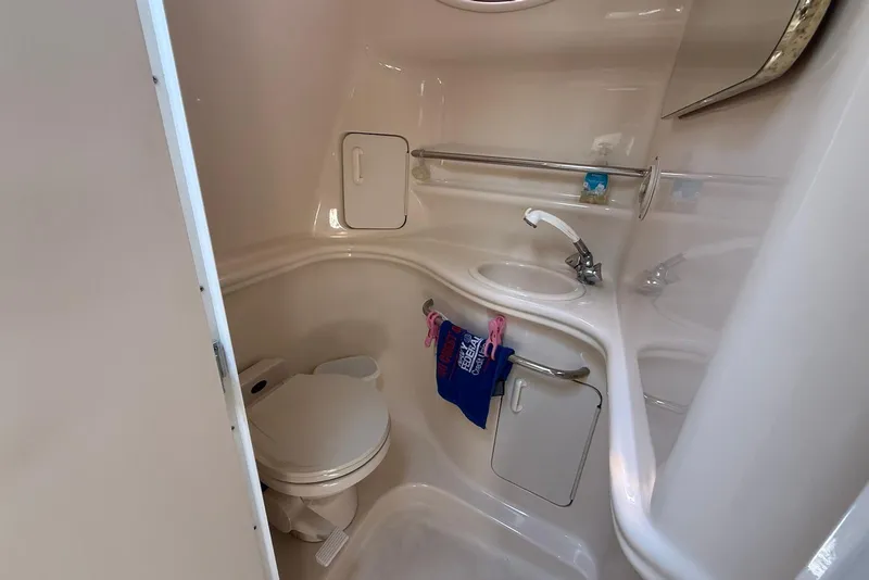 Slide: The Image of Compact bathroom in a 2001 Sea Ray 340 Sundancer yacht, featuring a toilet and sink. - 20