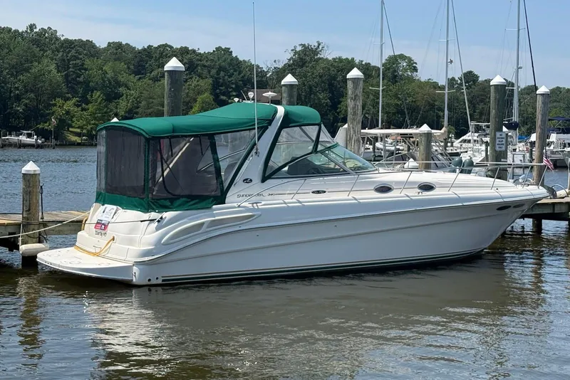 Slide: The Image of 2001 Sea Ray 340 Sundancer boat docked at a marina with green canopy. - 1