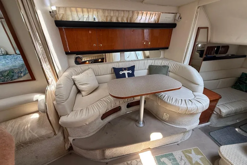 Slide: The Image of Interior of 2001 Sea Ray 340 Sundancer with curved seating and wooden cabinets. - 14