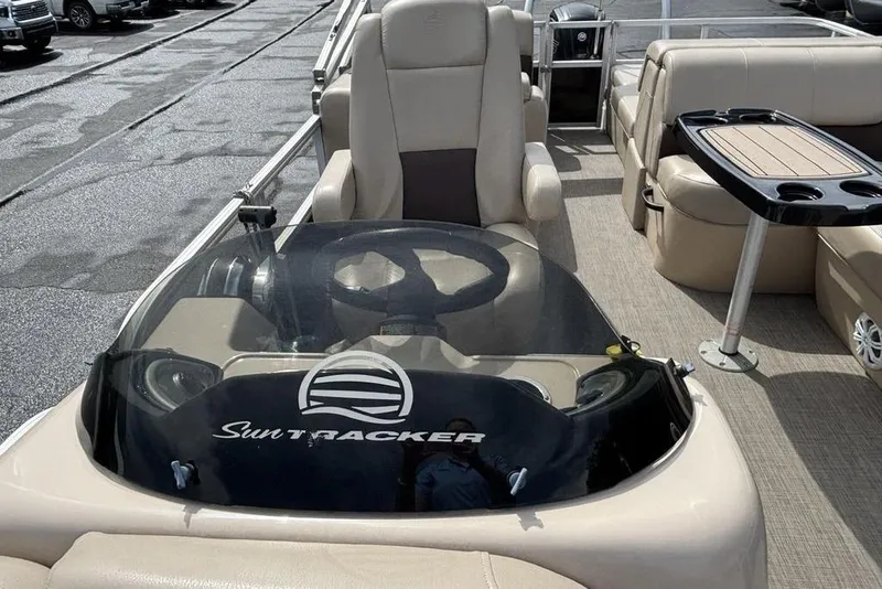 Slide: The Image of 2019 Sun Tracker Party Barge 22 RF DLX interior with steering console and seating area. - 22