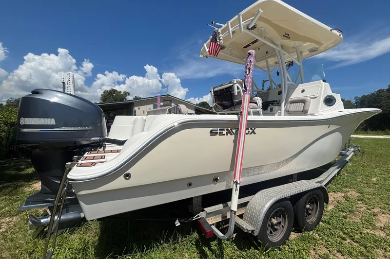 Slide: The Image of 2016 Sea Fox 249 Avenger boat on trailer, featuring Yamaha outboard motor, under clear blue sky. - 2