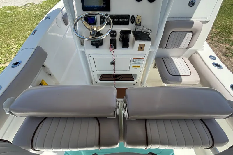 Slide: The Image of 2016 Sea Fox 249 Avenger boat cockpit with steering wheel and cushioned seating. - 19