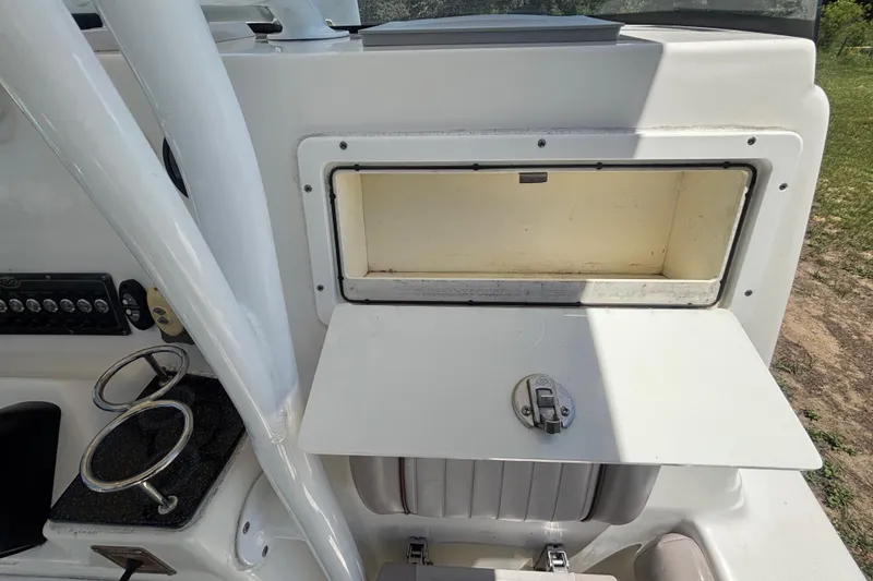 Slide: The Image of 2016 Sea Fox 249 Avenger boat storage compartment with open hatch and cup holders. - 37
