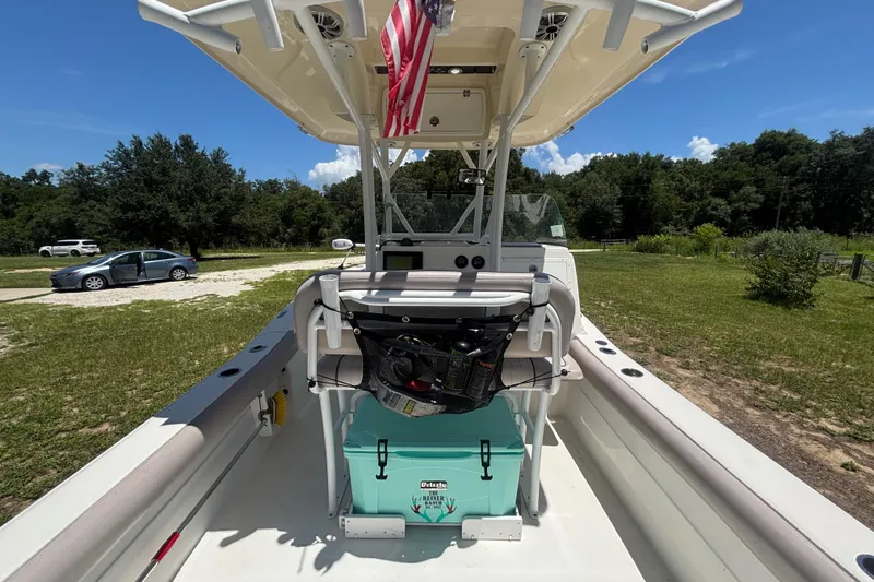 Slide: The Image of 2016 Sea Fox 249 Avenger boat with American flag, parked on grassy area. - 16