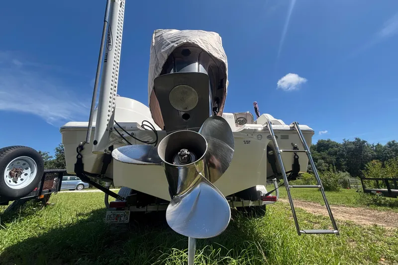 Slide: The Image of 2016 Sea Fox 249 Avenger boat rear view with propeller and ladder on grassy field. - 90