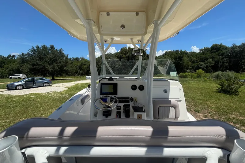 Slide: The Image of 2016 Sea Fox 249 Avenger boat cockpit with steering wheel and controls, parked on grass. - 18