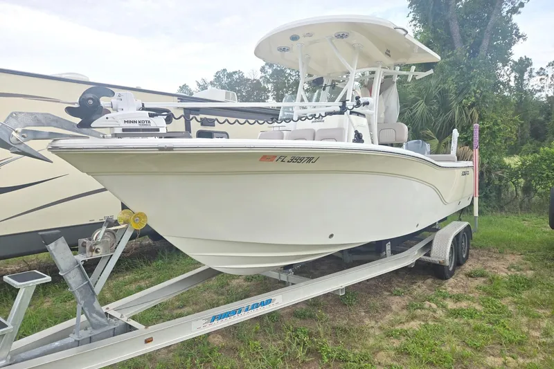 The Image of A white 2016 Sea Fox 249 Avenger boat on a trailer, surrounded by trees. - 0