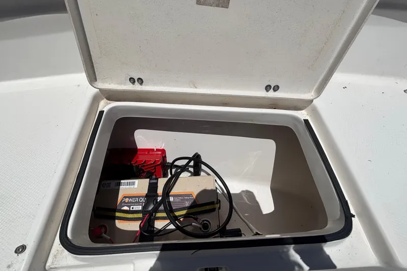 Slide: The Image of Open storage compartment on 2016 Sea Fox 249 Avenger boat with battery and cables. - 62