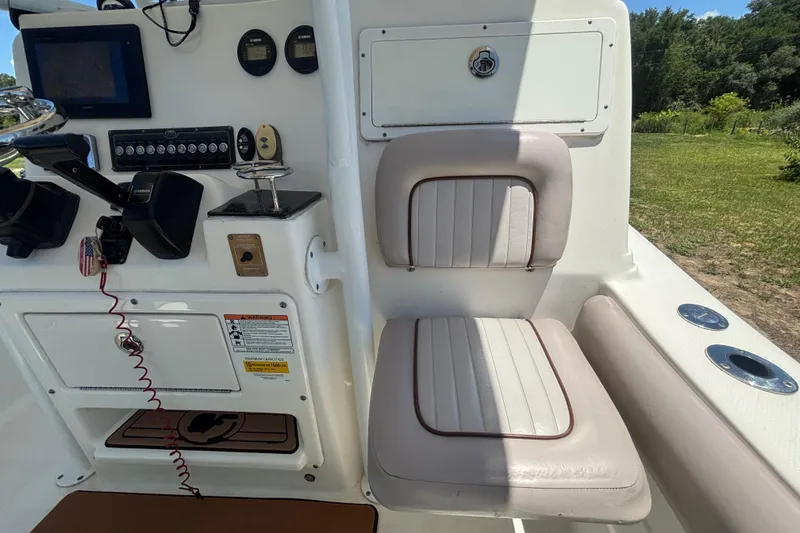 Slide: The Image of Interior of 2016 Sea Fox 249 Avenger boat, featuring control panel and cushioned seating. - 36