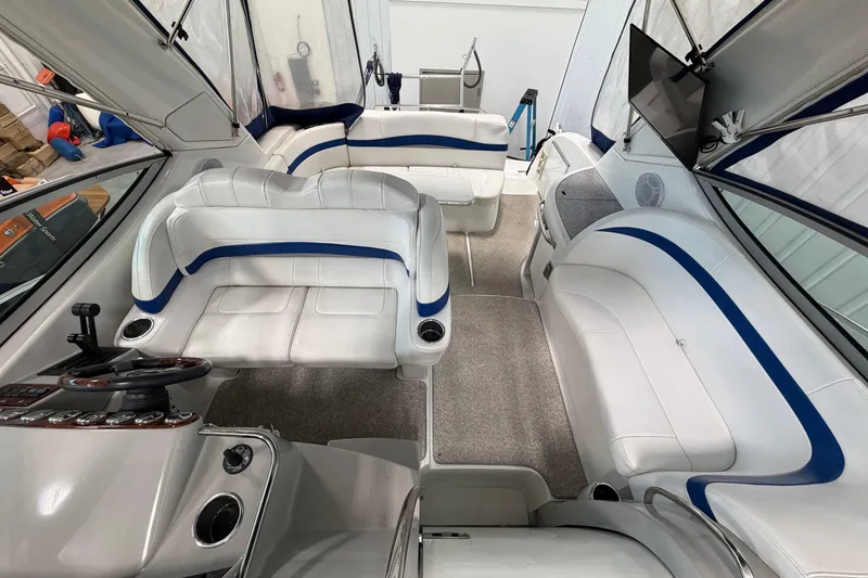 Slide: The Image of 2004 Formula 34 Performance Cruiser interior with white and blue seating, modern helm, and TV. - 17