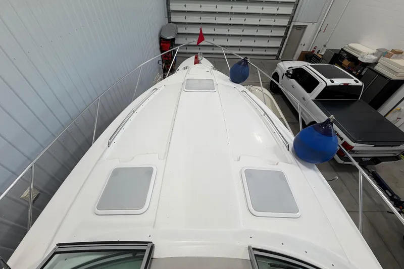 Slide: The Image of 2004 Formula 34 Performance Cruiser in storage, top view with blue fenders and nearby vehicles. - 32
