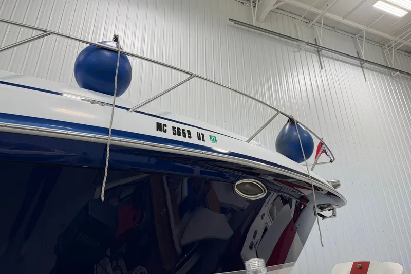 Slide: The Image of 2004 Formula 34 Performance Cruiser in storage, featuring blue fenders and registration number. - 2