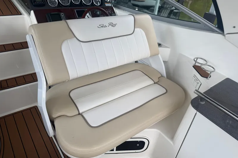 Slide: The Image of Captain's seat on 2012 Sea Ray Sundancer 310 boat, featuring beige and white upholstery. - 13