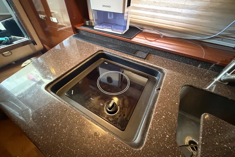 Slide: The Image of Modern kitchen area in a 2012 Sea Ray Sundancer 310 yacht with sleek cooktop. - 28