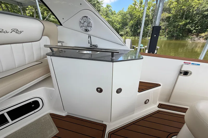 Slide: The Image of Interior of 2012 Sea Ray Sundancer 310 with seating and sink, docked by a lake. - 10