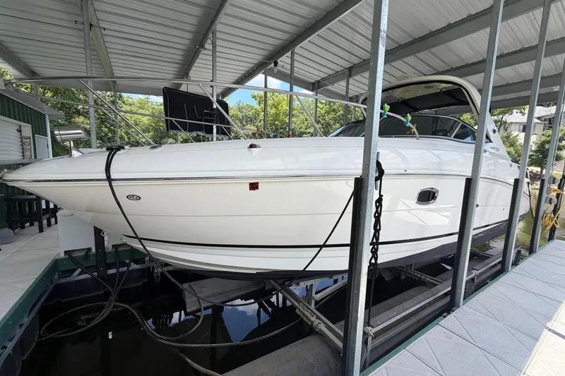 Slide: The Image of 2012 Sea Ray Sundancer 310 boat docked under a covered marina. - 1