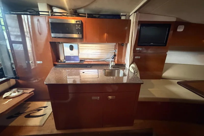 Slide: The Image of Interior of a 2012 Sea Ray Sundancer 310 yacht with kitchenette and seating area. - 26